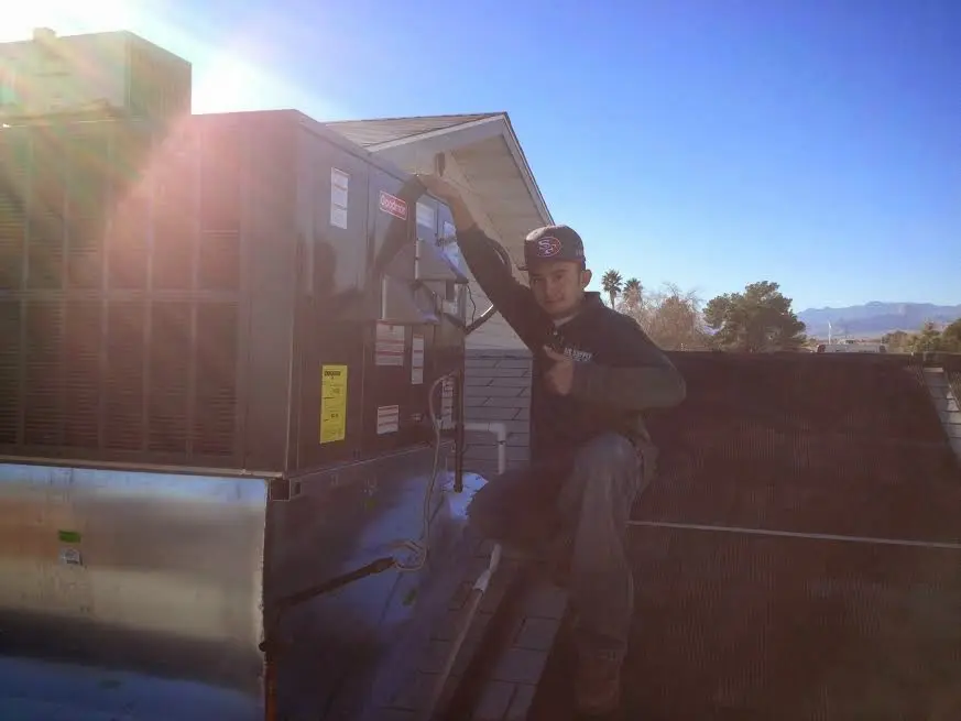 HVAC technician performing AC Tune-Up on a rooftop unit in Rehoboth